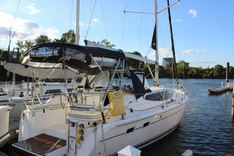The Image of 2014 Hunter 33 sailboat docked on a sunny day by the water. - 0