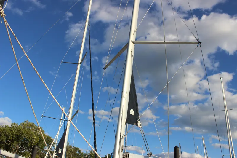 Slide: The Image of Masts of a 2014 Hunter 33 sailboat against a blue sky with clouds. - 10