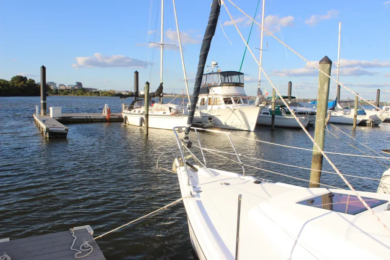 Slide: The Image of Sailboats docked at a marina, featuring a 2014 Hunter 33 model under a clear blue sky. - 13