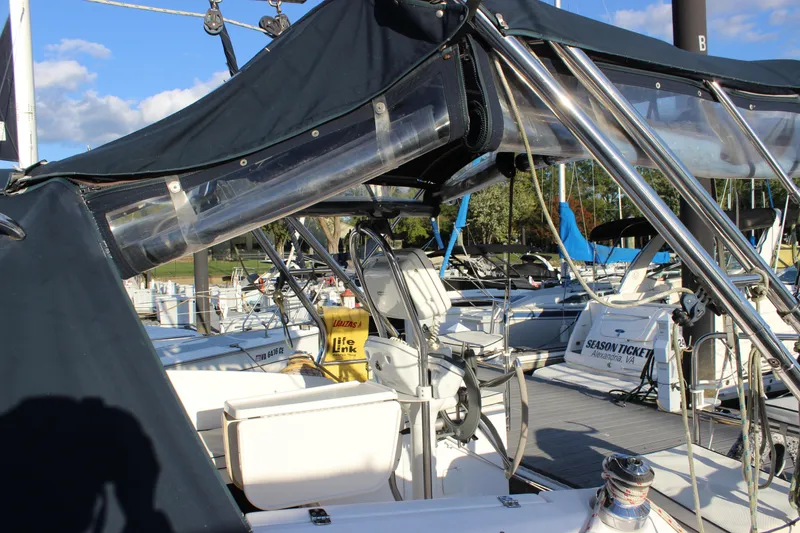 Slide: The Image of 2014 Hunter 33 sailboat docked, featuring cockpit and canopy, with marina background. - 14