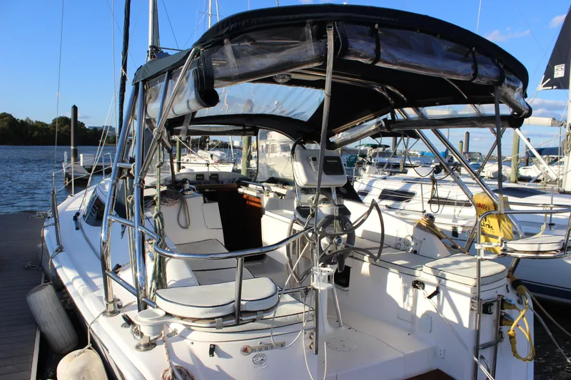 Slide: The Image of 2014 Hunter 33 sailboat docked, featuring a spacious cockpit and modern navigation equipment. - 2