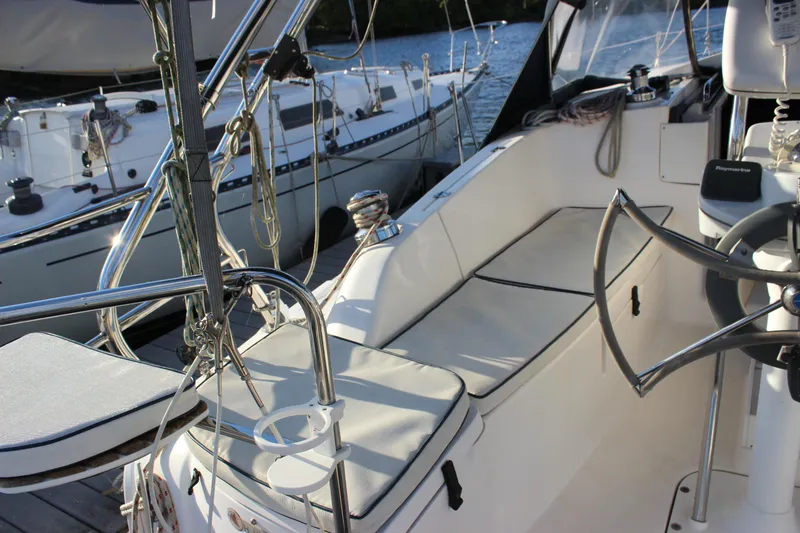 Slide: The Image of 2014 Hunter 33 sailboat cockpit with seating and steering wheel, docked at marina. - 21