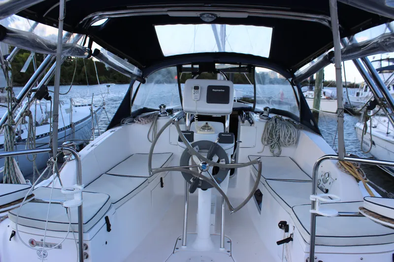 Slide: The Image of 2014 Hunter 33 sailboat cockpit with steering wheel, navigation equipment, and seating. - 32