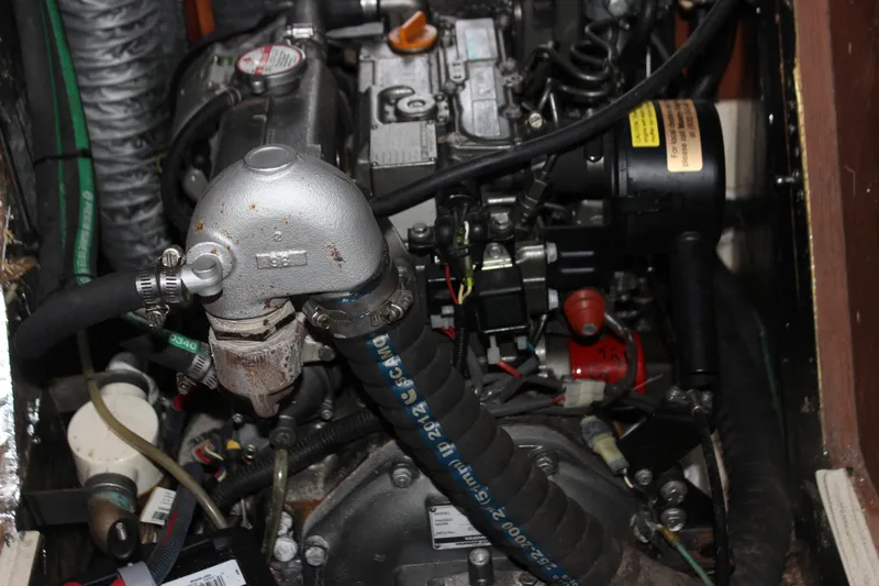 Slide: The Image of Engine compartment of a 2014 Hunter 33 sailboat, showcasing mechanical components and hoses. - 35