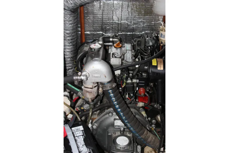 Slide: The Image of Engine compartment of a 2014 Hunter 33 sailboat, showcasing mechanical components and hoses. - 36