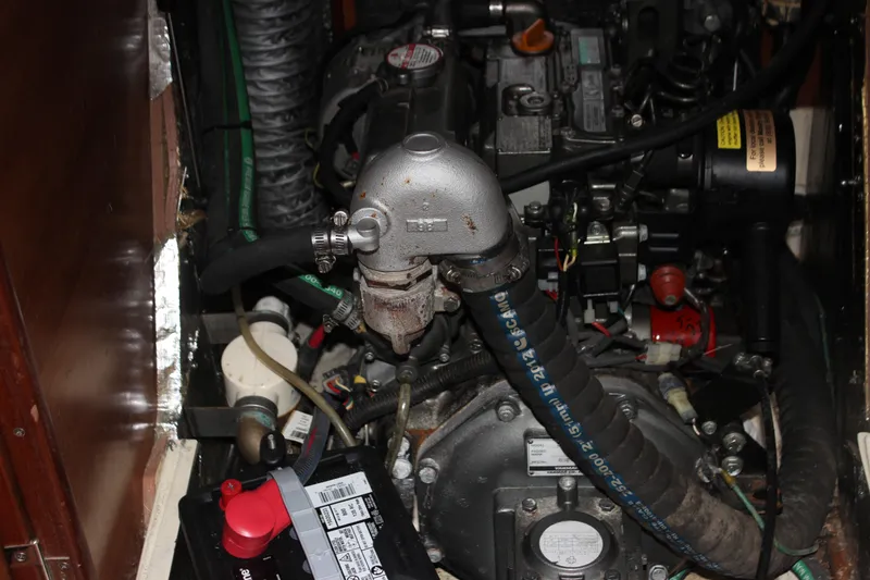 Slide: The Image of Engine compartment of a 2014 Hunter 33 sailboat, featuring hoses and battery. - 37