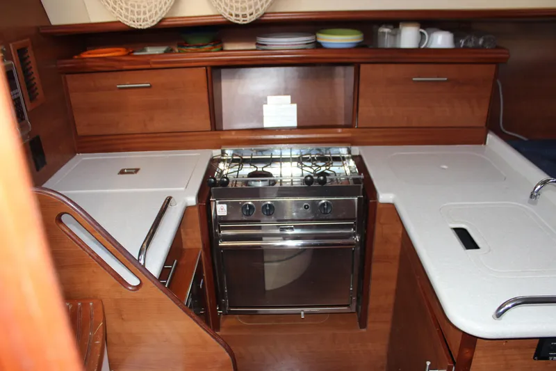 Slide: The Image of 2014 Hunter 33 yacht kitchen with stove, wooden cabinets, and countertop. - 39