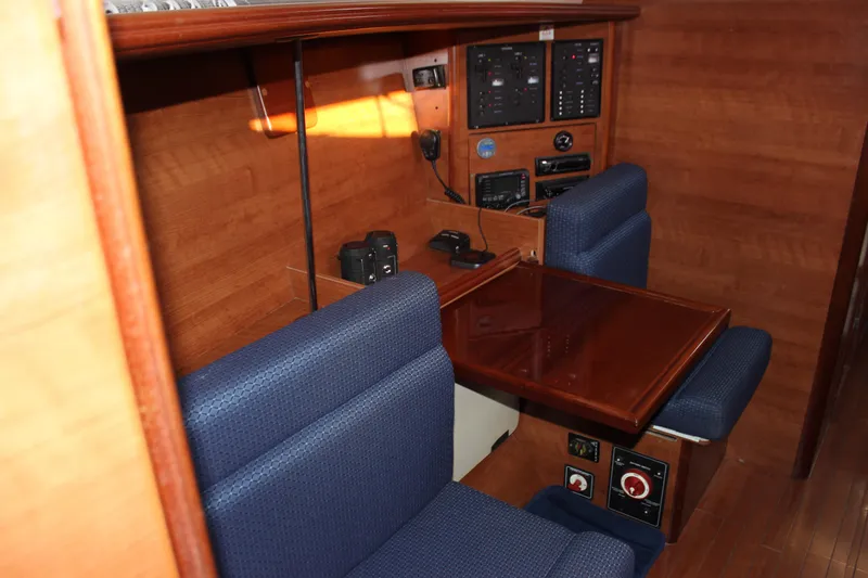 Slide: The Image of 2014 Hunter 33 yacht interior with navigation station and blue seating. - 43