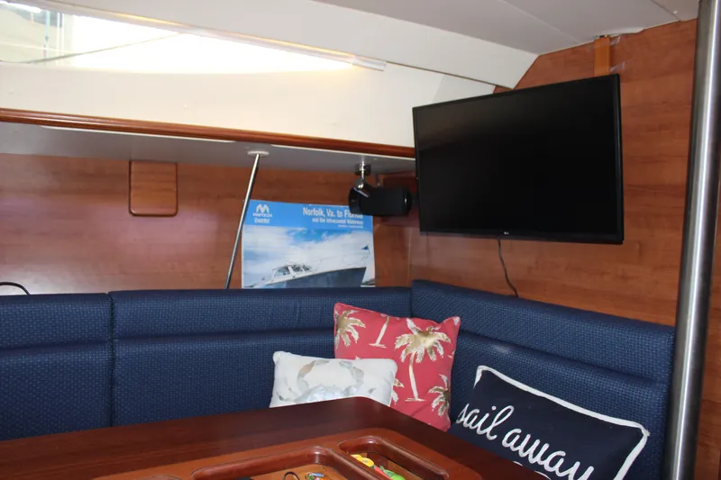 Slide: The Image of Interior of 2014 Hunter 33 yacht with TV, cushions, and wooden paneling. - 48
