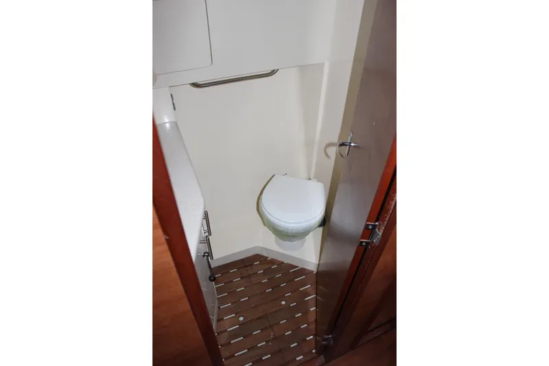 Slide: The Image of 2014 Hunter 33 yacht bathroom with compact toilet and wooden flooring. - 55