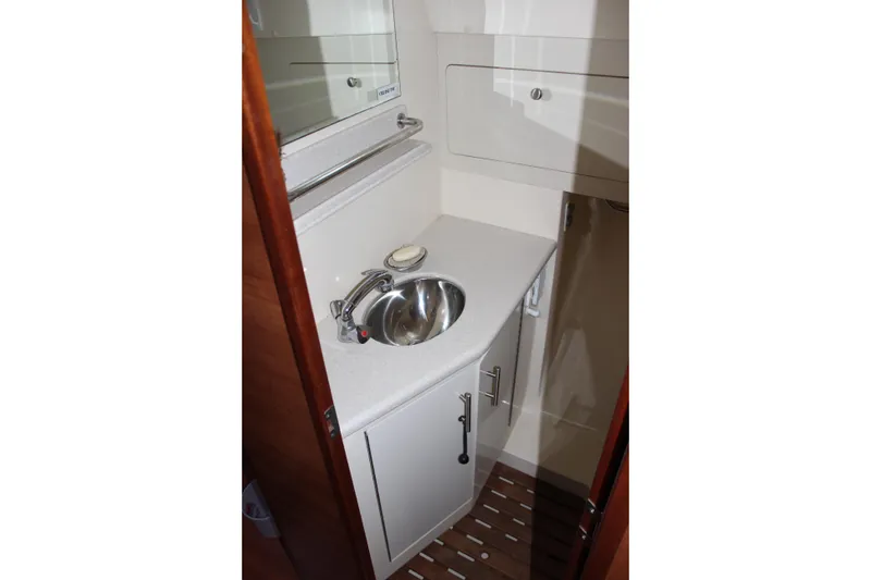 Slide: The Image of Compact bathroom sink area in 2014 Hunter 33 yacht, featuring modern fixtures and storage. - 56
