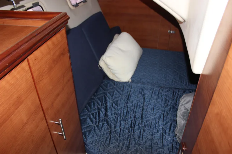 Slide: The Image of Cozy cabin interior of 2014 Hunter 33 sailboat with blue bedding and wooden cabinetry. - 58