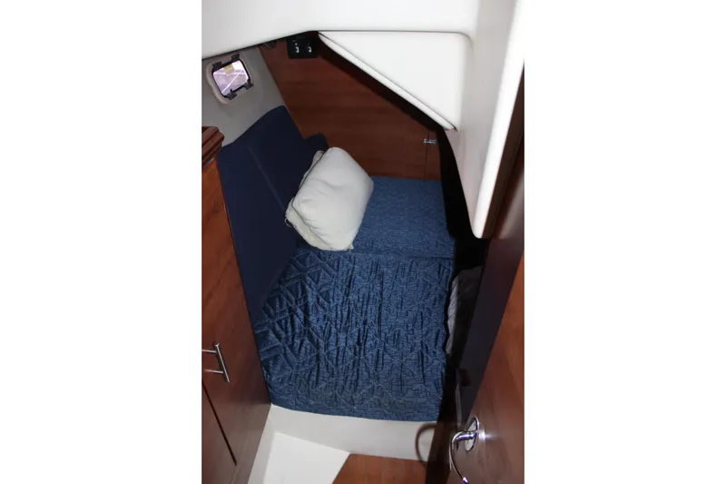 Slide: The Image of 2014 Hunter 33 yacht cabin interior with blue bedding and wooden finish. - 59