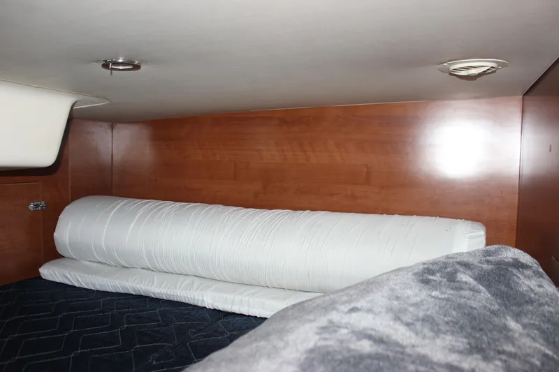 Slide: The Image of Interior cabin of 2014 Hunter 33 sailboat with wooden paneling and bedding. - 63