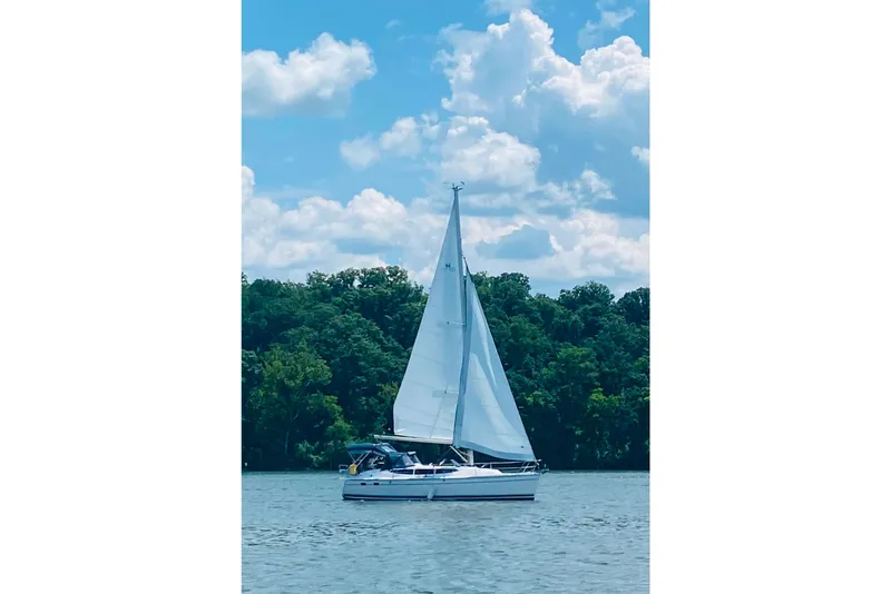 Slide: The Image of Sailboat Hunter 33 (2014) cruising on a serene lake under a blue sky. - 65