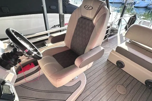 Slide: The Image of Captain's chair on 2021 Harris Solstice 230 pontoon boat, featuring luxury seating and steering wheel. - 12