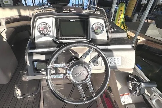 Slide: The Image of 2021 Harris Solstice 230 boat dashboard with steering wheel and control panel. - 13