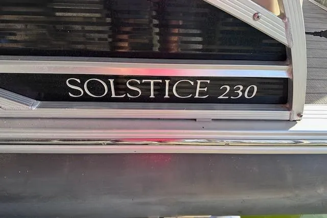 Slide: The Image of 2021 Harris Solstice 230 boat nameplate with sleek design and metallic finish. - 14