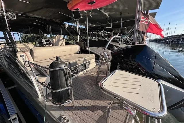 Slide: The Image of 2021 Harris Solstice 230 pontoon boat docked, featuring comfortable seating and sleek design. - 2