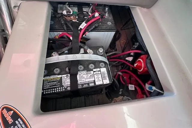 Slide: The Image of Battery compartment of a 2021 Harris Solstice 230 boat with visible wiring and connections. - 24