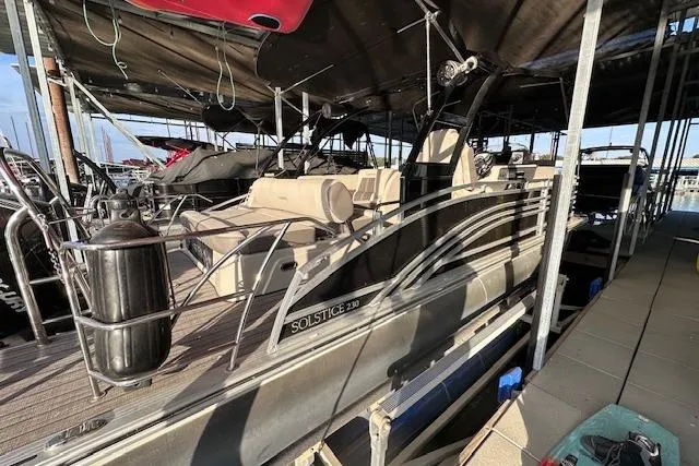 Slide: The Image of 2021 Harris Solstice 230 pontoon boat docked under a canopy. - 3