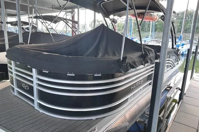 Slide: The Image of 2021 Harris Solstice 230 pontoon boat covered at a marina dock. - 4