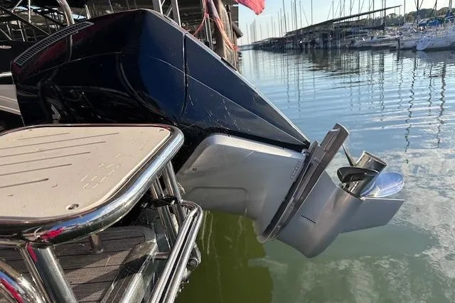 Slide: The Image of 2021 Harris Solstice 230 boat engine at marina, reflecting on calm water. - 6