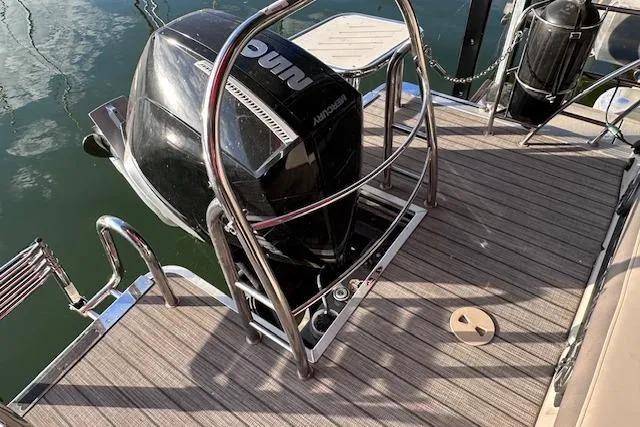 Slide: The Image of 2021 Harris Solstice 230 boat with outboard motor on a wooden deck. - 8