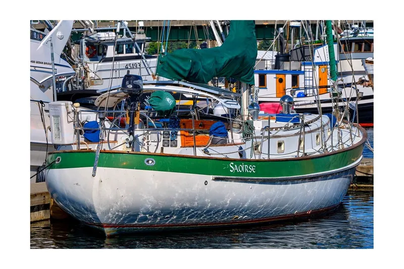 The Image of 1981 Valiant Cutter sailboat docked in a marina, featuring green accents and nautical equipment. - 0