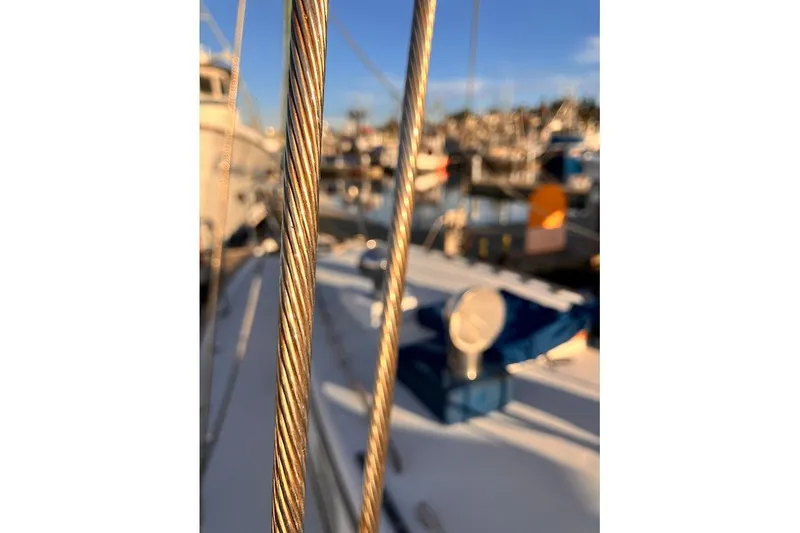 Slide: The Image of Close-up of Valiant Cutter 1981 sailboat rigging with marina in background. - 13