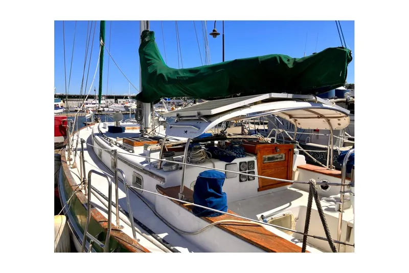 Slide: The Image of 1981 Valiant Cutter sailboat docked in a sunny marina, featuring green sail cover. - 27
