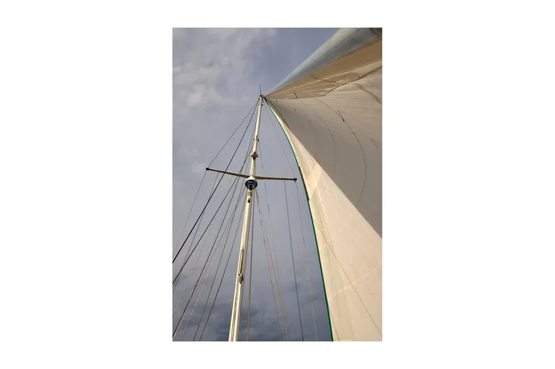 Slide: The Image of 1981 Valiant Cutter sailboat mast and sail against cloudy sky. - 3