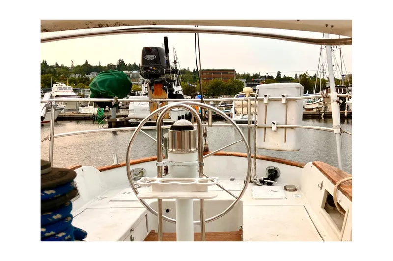 Slide: The Image of 1981 Valiant Cutter sailboat cockpit with steering wheel, docked at marina. - 30