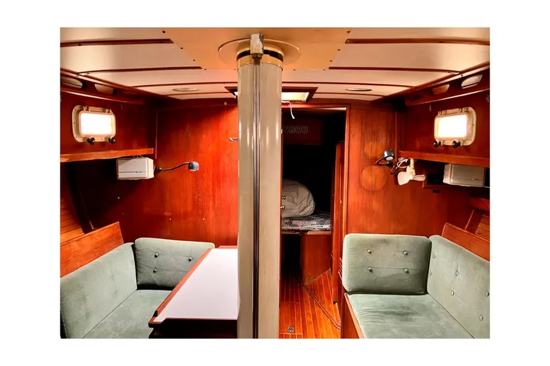 Slide: The Image of Interior of 1981 Valiant Cutter sailboat with wooden paneling and green seating. - 5