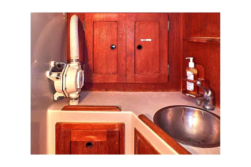 Slide: The Image of 1981 Valiant Cutter boat bathroom with wooden cabinets, sink, and soap dispenser. - 51