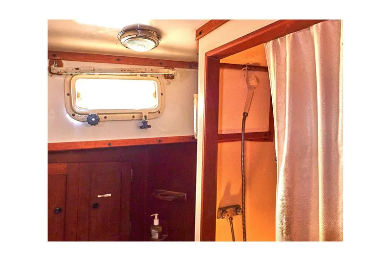 Slide: The Image of 1981 Valiant Cutter interior with shower, wooden cabinetry, and porthole window. - 52