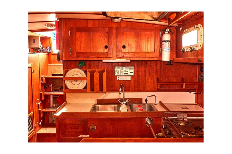 Slide: The Image of 1981 Valiant Cutter yacht interior with wooden cabinetry and kitchen area. - 59