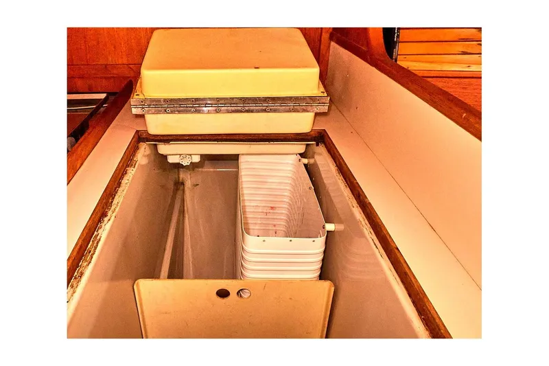 Slide: The Image of 1981 Valiant Cutter interior storage compartment with wooden trim and plastic container. - 64