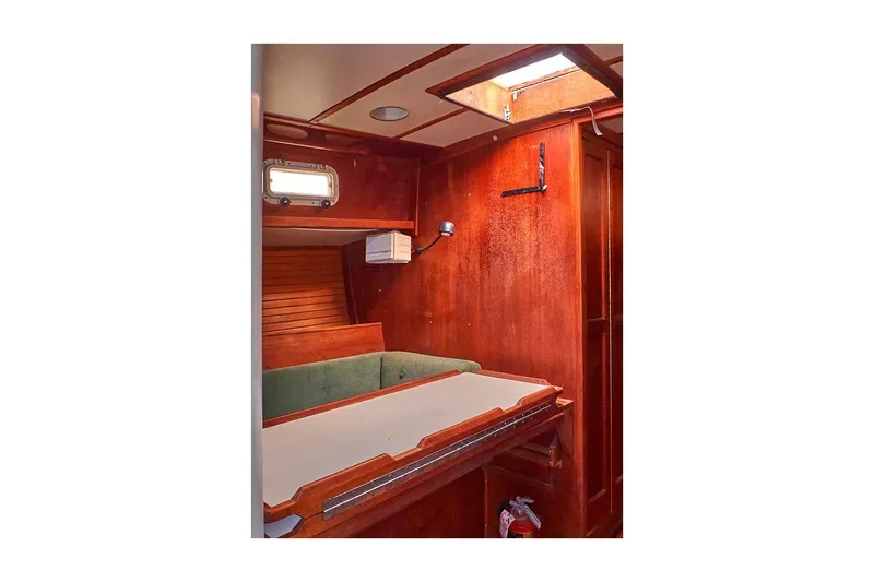 Slide: The Image of Interior of 1981 Valiant Cutter sailboat with wooden paneling and green seating. - 66