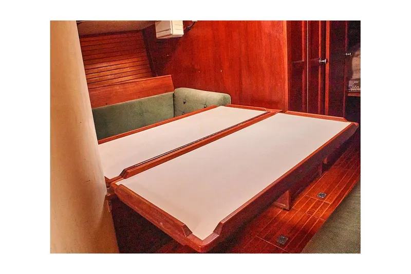 Slide: The Image of Interior of 1981 Valiant Cutter sailboat with wooden table and green seating. - 67