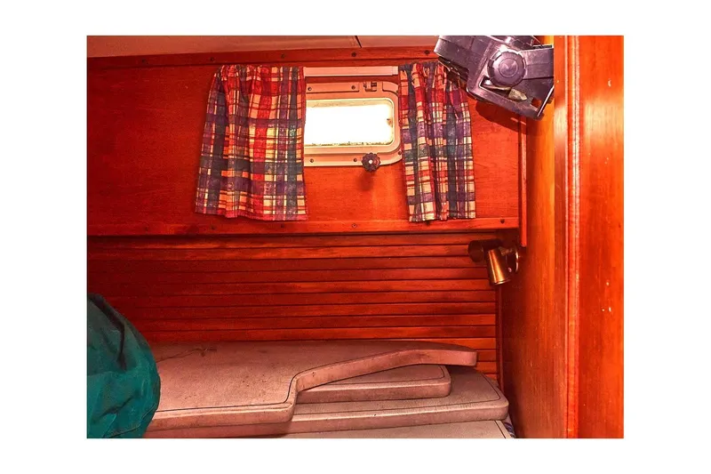 Slide: The Image of 1981 Valiant Cutter cabin interior with plaid curtains and wooden paneling. - 80