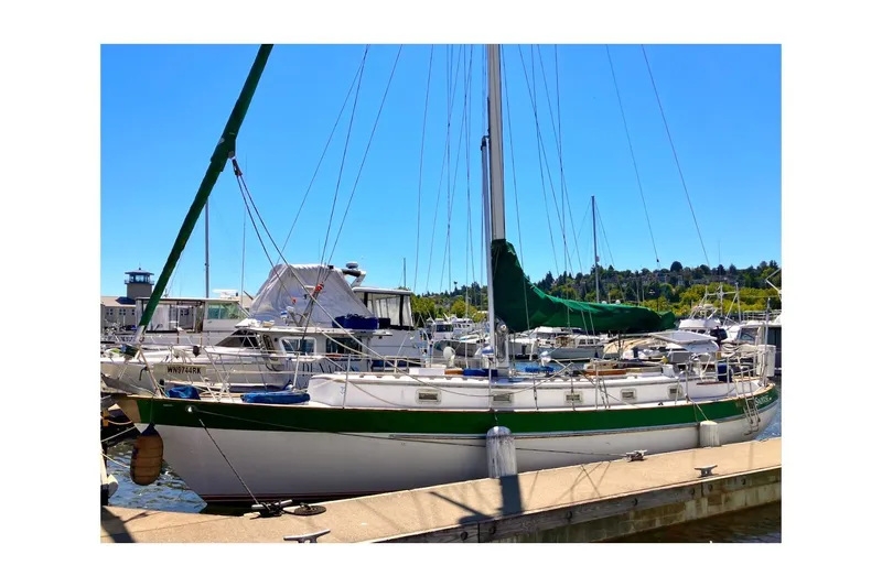 Slide: The Image of 1981 Valiant Cutter sailboat docked at marina under clear blue sky. - 9