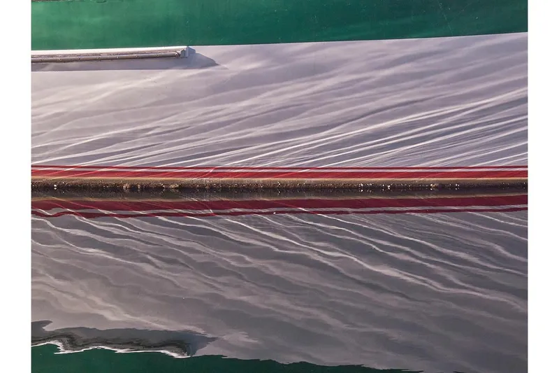 Slide: The Image of Close-up of 1981 Valiant Cutter boat hull with water reflections. - 94