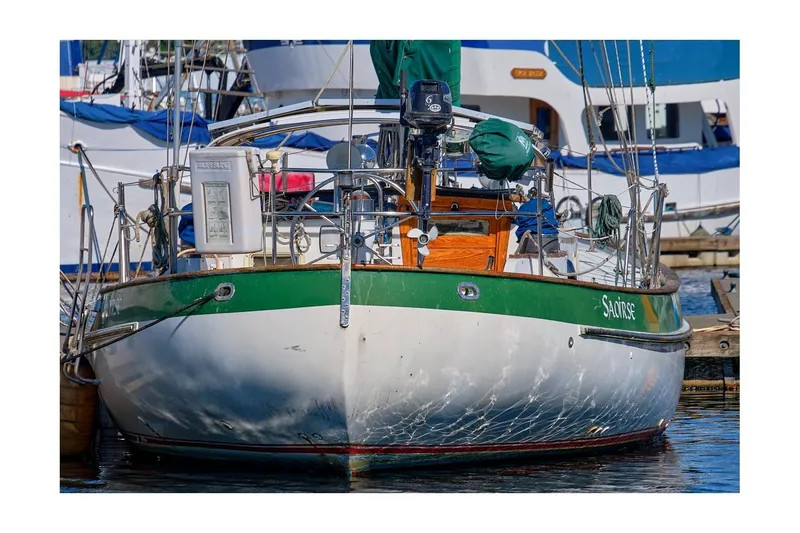 Slide: The Image of 1981 Valiant Cutter sailboat docked, featuring green and white hull with nautical equipment. - 95