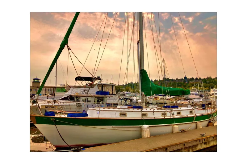 Slide: The Image of 1981 Valiant Cutter sailboat docked at marina under vibrant sunset sky. - 96