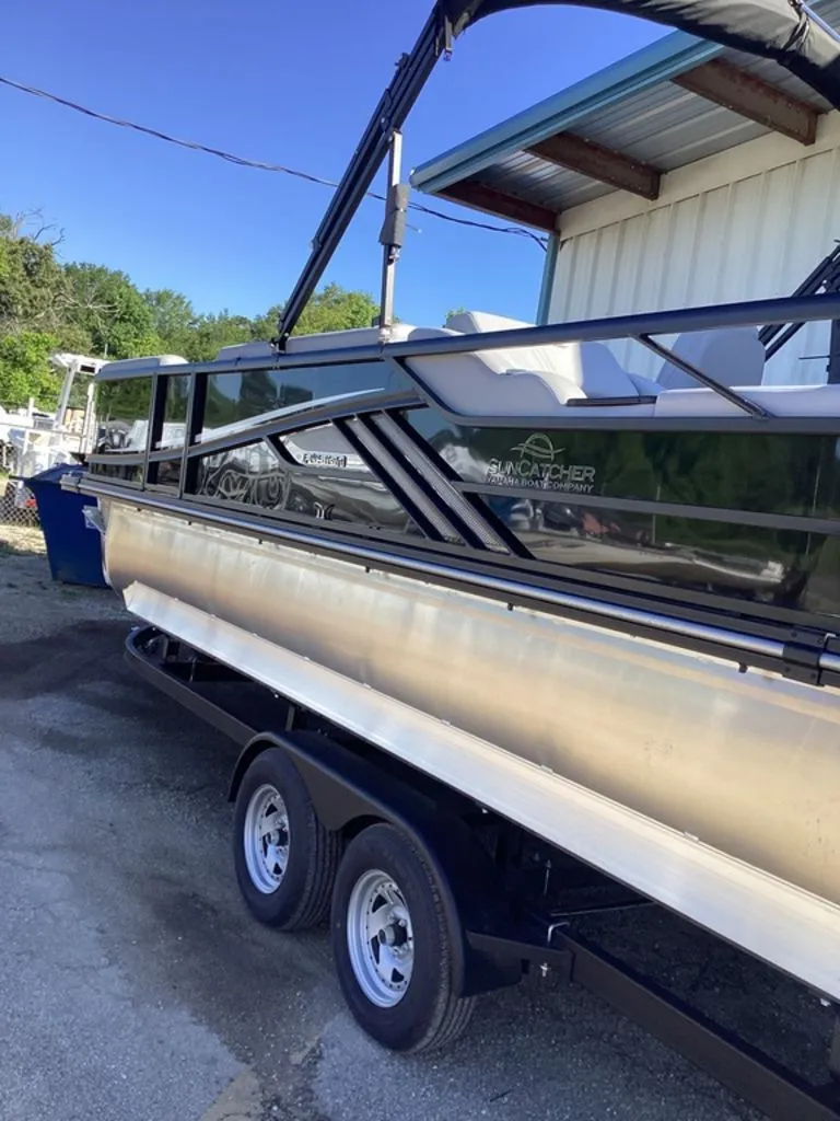 Slide: The Image of 2026 SunCatcher Fusion 324SS boat parked on trailer. - 11