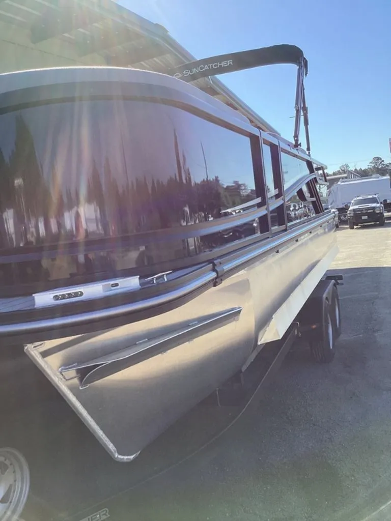 Slide: The Image of 2026 SunCatcher Fusion 324SS boat in sunlight on a trailer. - 13