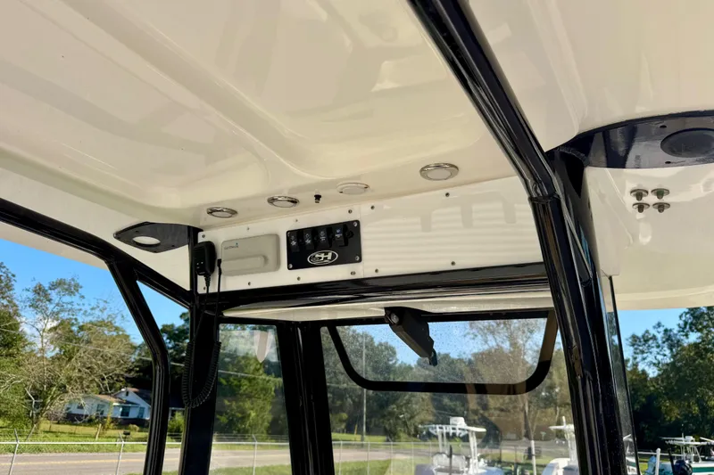 Slide: The Image of 2018 Sea Hunt BX 25 FS boat console with controls and canopy, outdoor setting. - 12