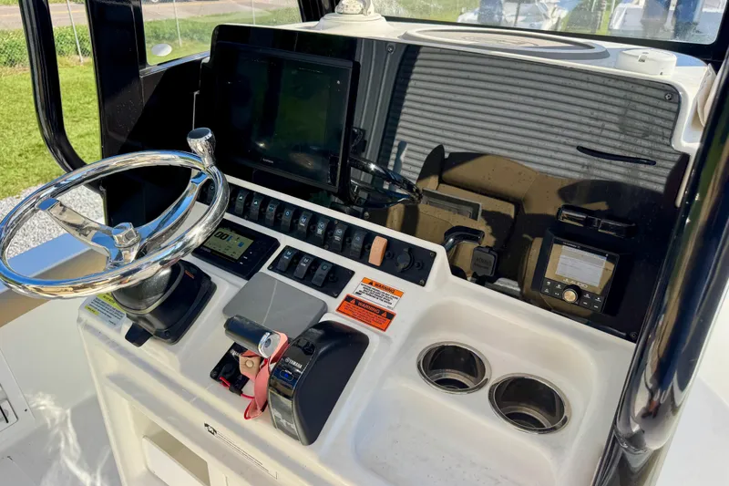 Slide: The Image of 2018 Sea Hunt BX 25 FS boat console with steering wheel, controls, and electronic displays. - 13