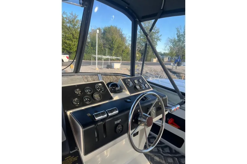 Slide: The Image of 1993 Carver 350 Aft Cabin Motor Yacht helm with steering wheel and control panel. - 14